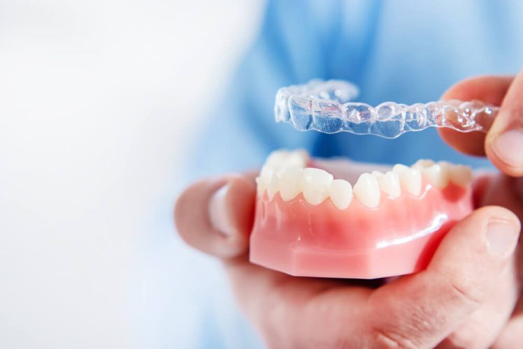 newmarket family dental dentist holds clear aligners up close